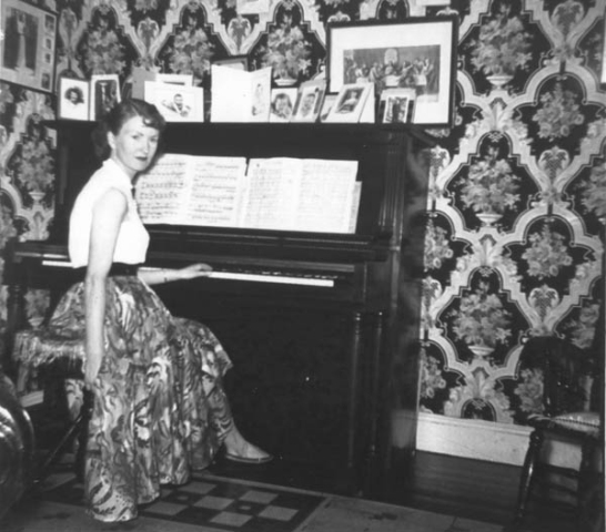 352: Reen McCarthy in the family parlour. The dark color in the wallpaper pattern is a deep red. (circa 1950)  - daughter of James McCarthy &amp;amp; Julia Reddy